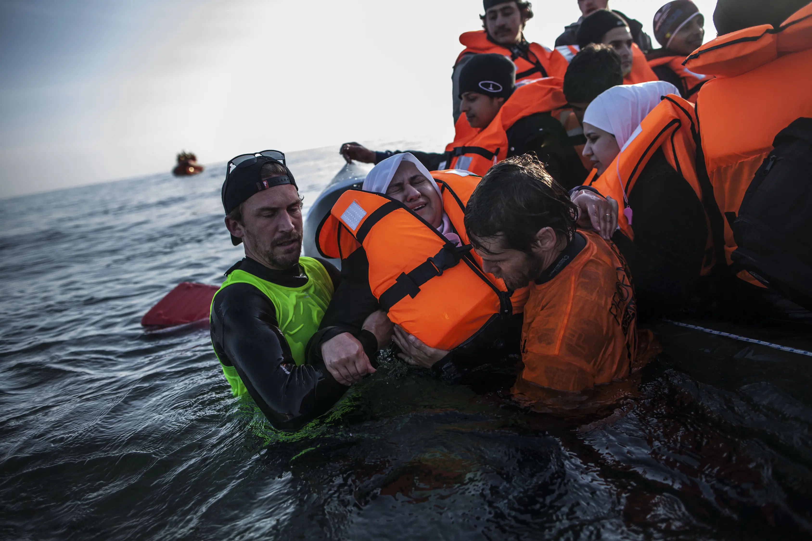 Volunteers help a Syrian refugee on the southeastern Greek island of Lesbos