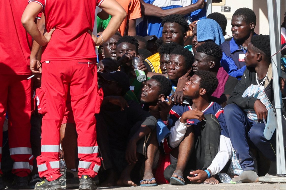Migrants gather at the hotspot, a reception centre for migrants