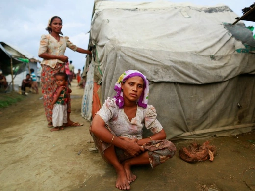 Sinnuyar Baekon, 25, sits in front of her hut at a refugee camp outside Sittwe, the capital city of the Rakhine state June 9, 2014. Baekon is among many Rohingya Muslims living in squalid camps in Myanmar after being displaced by religious unrest. Baekon is from Rakhine state, where her family home was burned down in religious riots that broke out in June 2012. Baekon ended up in a refugee camp, where she is still living now. Her husband left her before she gave birth to twins, and she is struggling to fee
