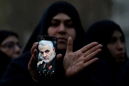 An Iranian woman shows a photo of Iranian Commander Qasem Soleimani on her cell phone during a protest against his killing in Tehran.