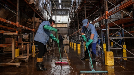 Workers remove mud accumulated by flooding at an industrial plant of hygiene, cleaning, and oleochemical products, in Encantado, Rio Grande do Sul, Brazil.